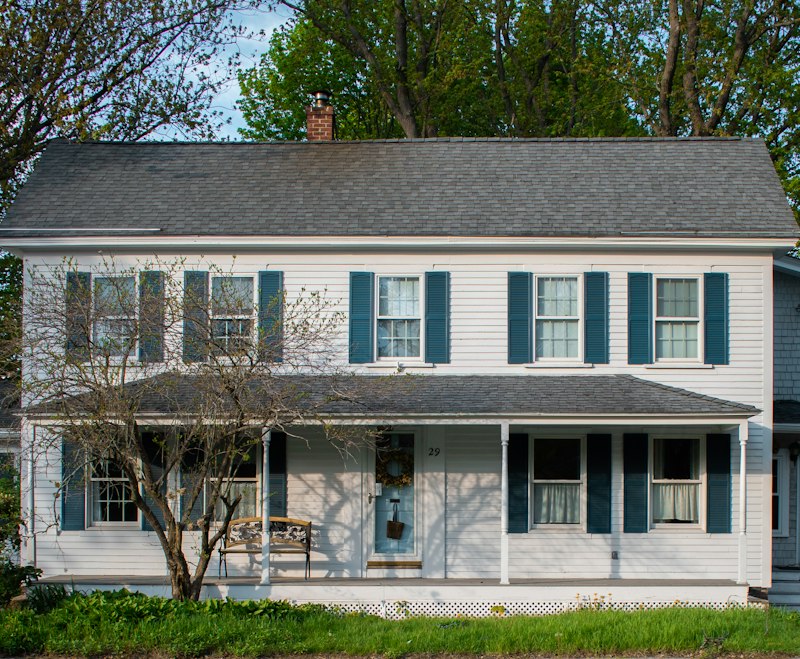 A white house with blue shutters and a porch
